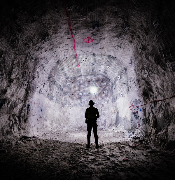 A mining engineer shines a light on the underground ore